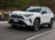 Toyota RAV4 blanche qui roule à toute vitesse sur une route bordée d'arbres