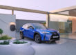 Lexus électrique bleue qui recharge devant une maison au style moderne