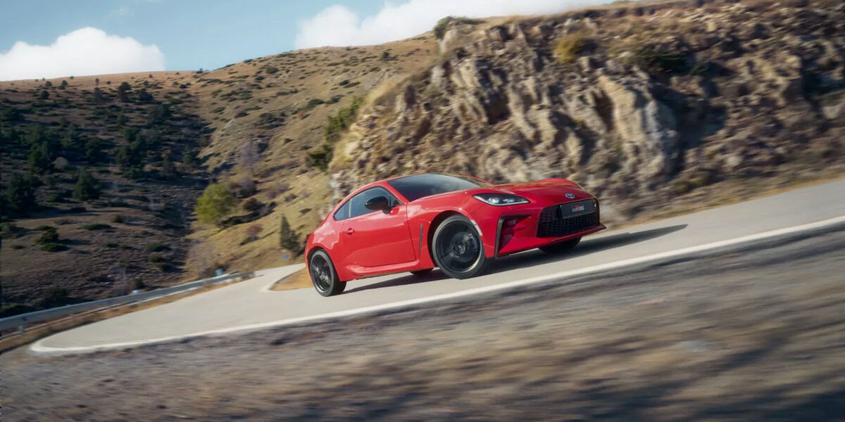 Voiture de sport Toyota GR86 rouge sur une route de montagne