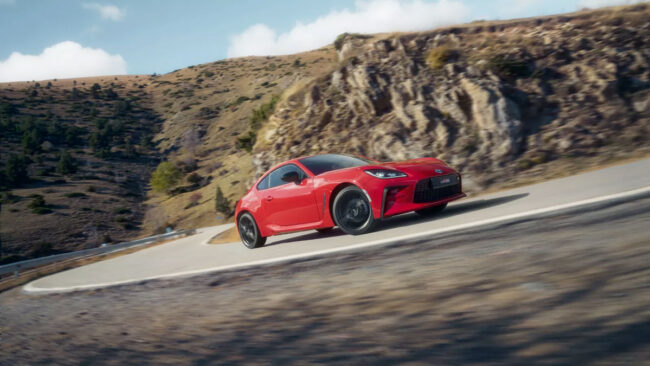 Voiture de sport Toyota GR86 rouge sur une route de montagne