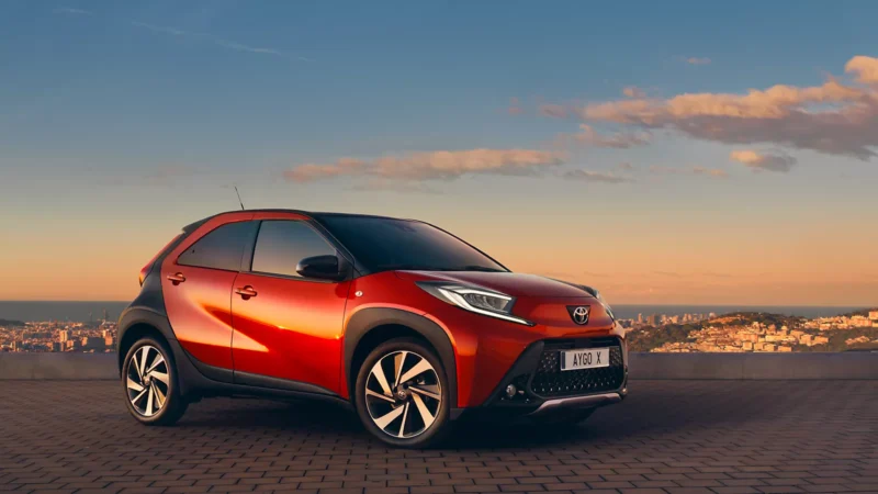 Toyota Aygo X rouge sur un fond de coucher de soleil