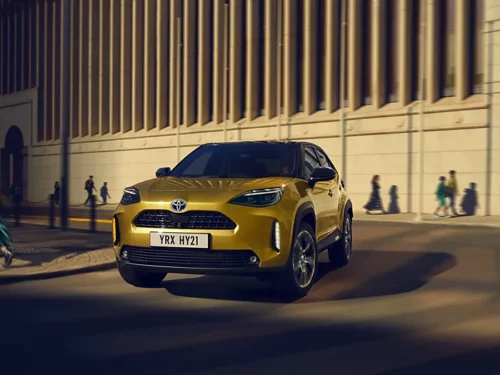 Voiture hybride Toyota dorée roulant en ville de nuit