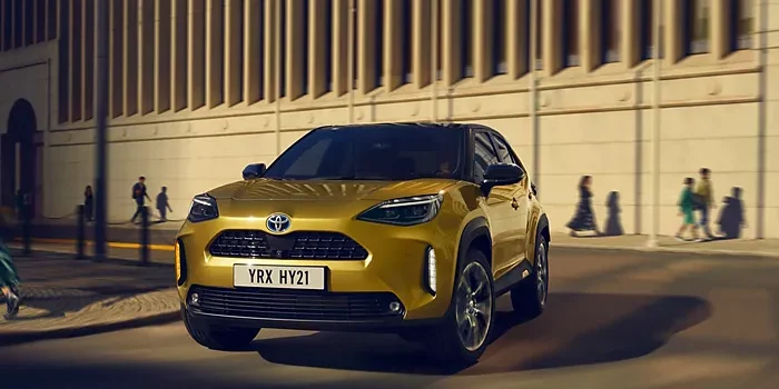 Medium-Landscape Voiture hybride Toyota dorée roulant en ville de nuit