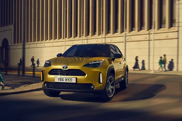 Voiture hybride Toyota dorée roulant en ville de nuit