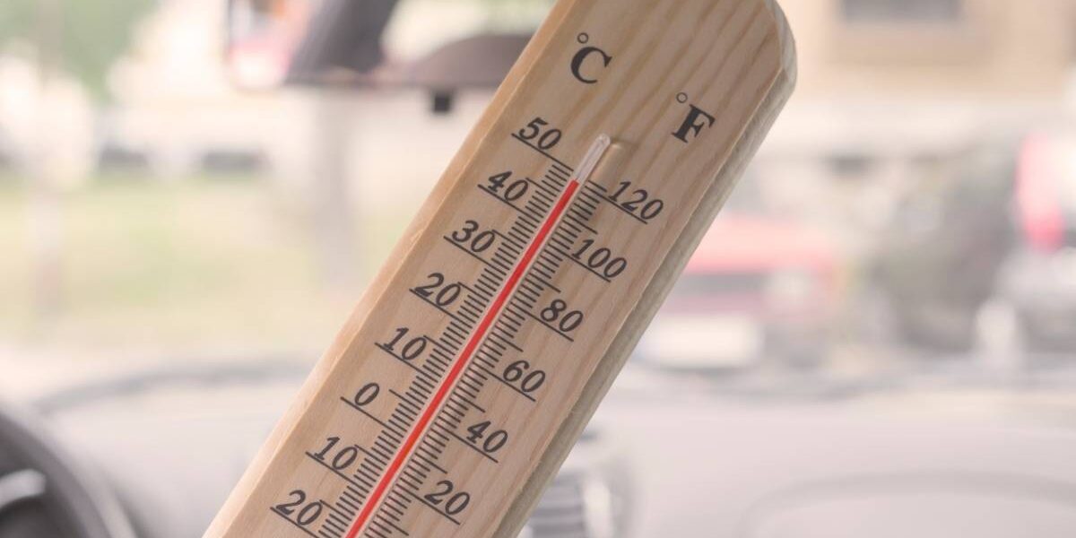 Thermomètre qui affiche 49°C dans l'habitacle d'une voiture en été