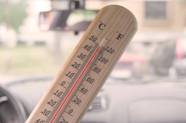 Thermomètre qui affiche 49°C dans l'habitacle d'une voiture en été
